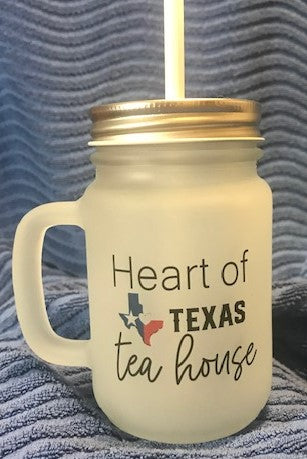 Mason jar cup with heart of Texas tea house colored logo on blue background